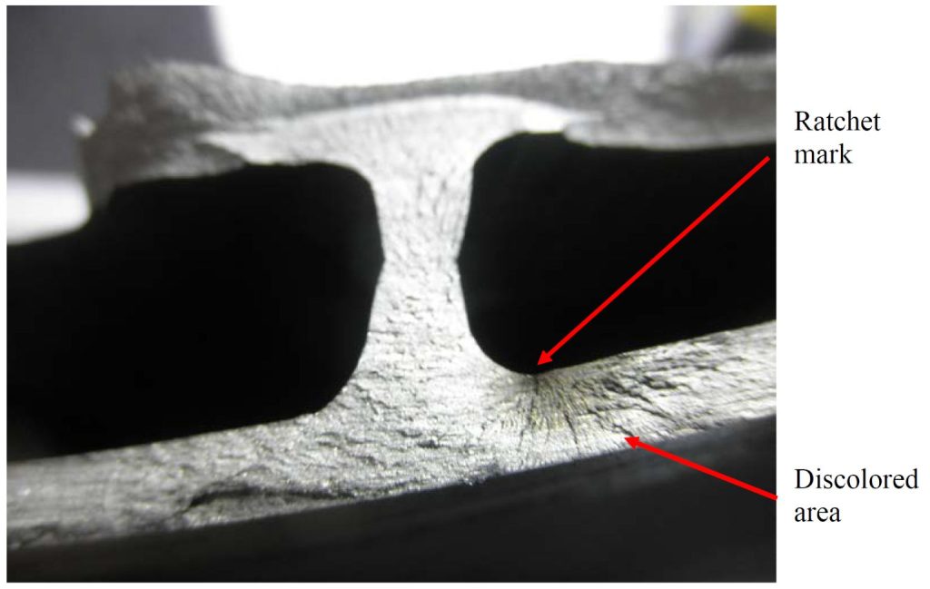 Zbliżenie powierzchni przełomu zmęczeniowego z widocznym ratchet mark