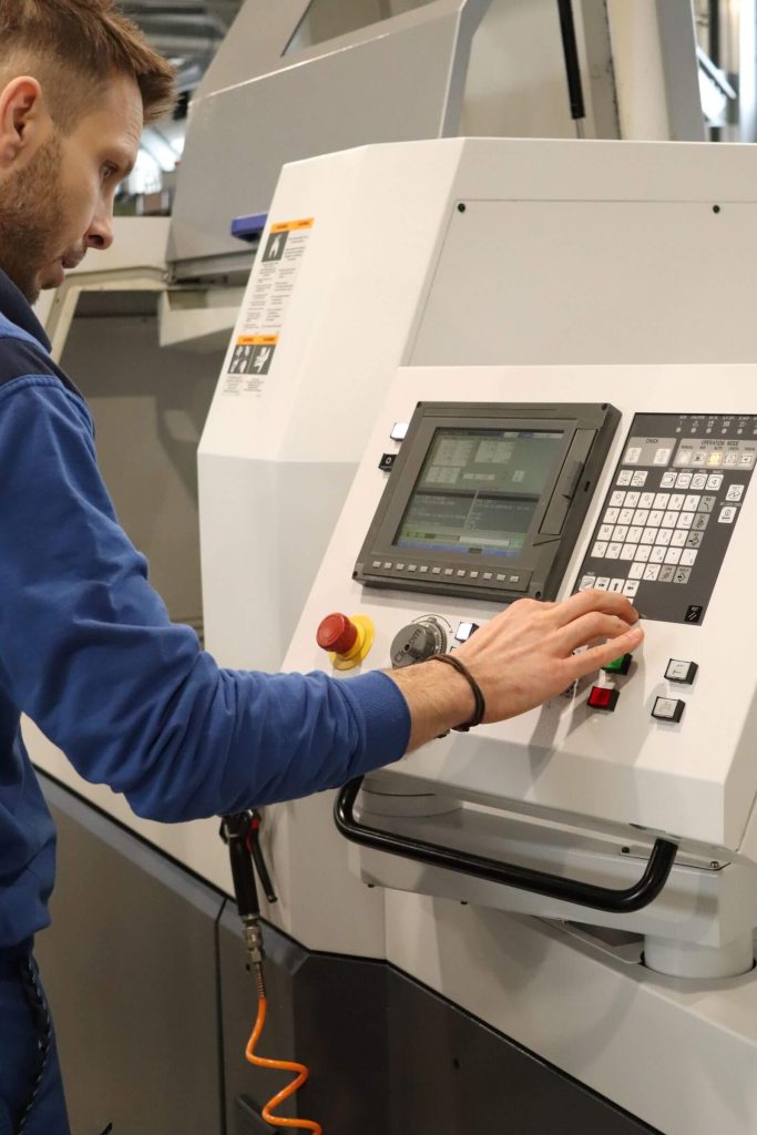 Technolog CNC podczas pracy przy obrabiarce w zakładzie SABNER